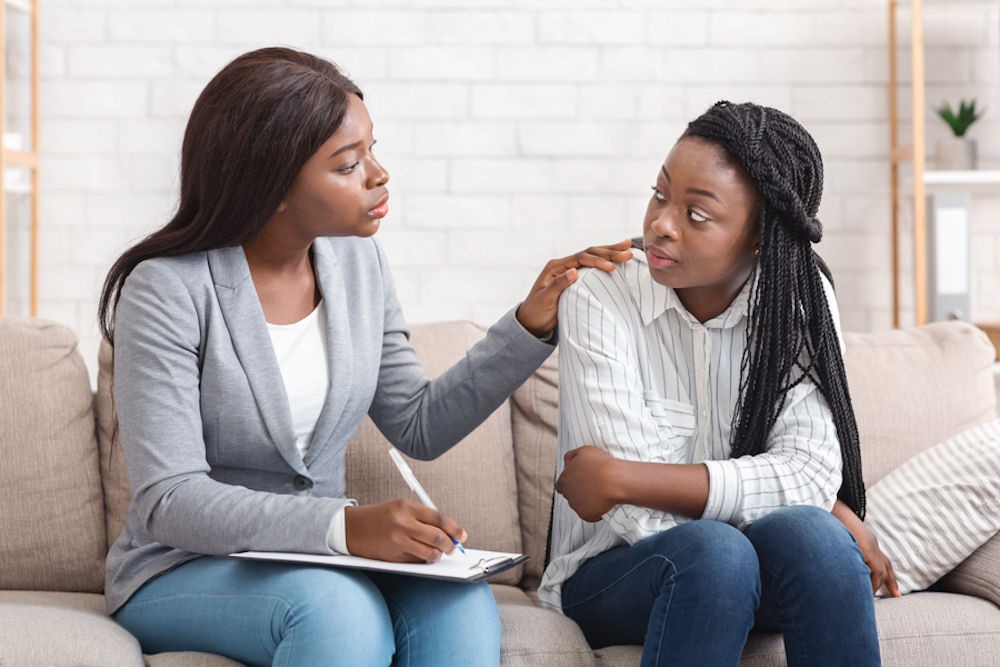 anxiety-and-anger-connection a woman with therapist touching shoulder in therapy