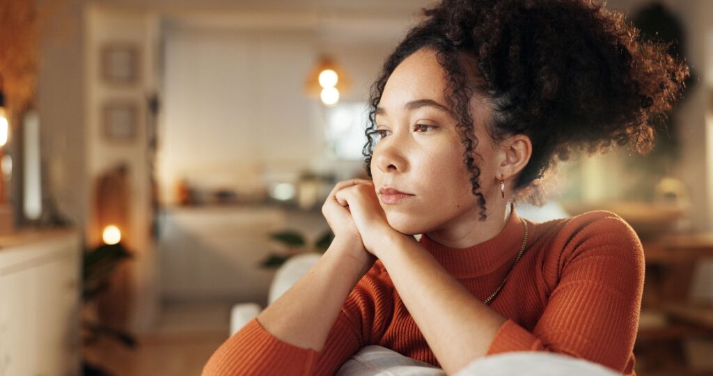 a woman deep in thought on couch