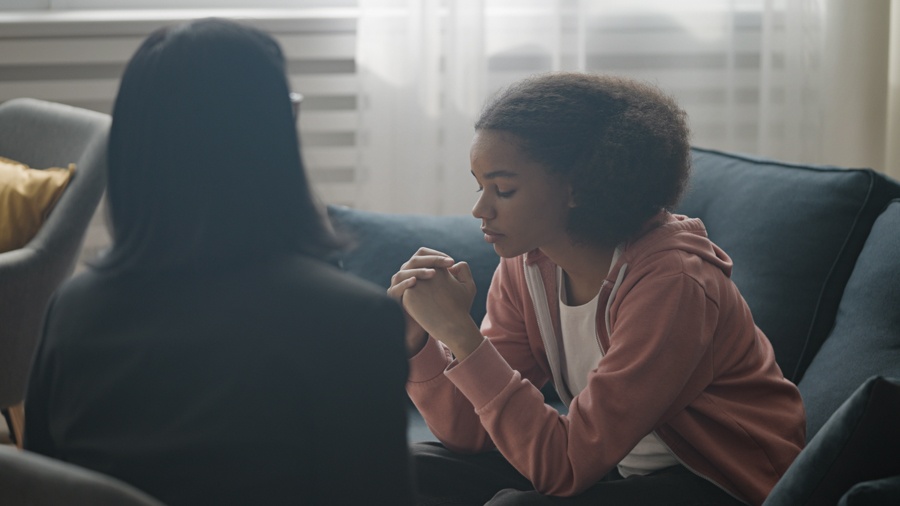 teen girl head down and eyes closed in therapy