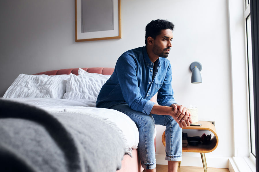 a man sitting on the bed deep in thought